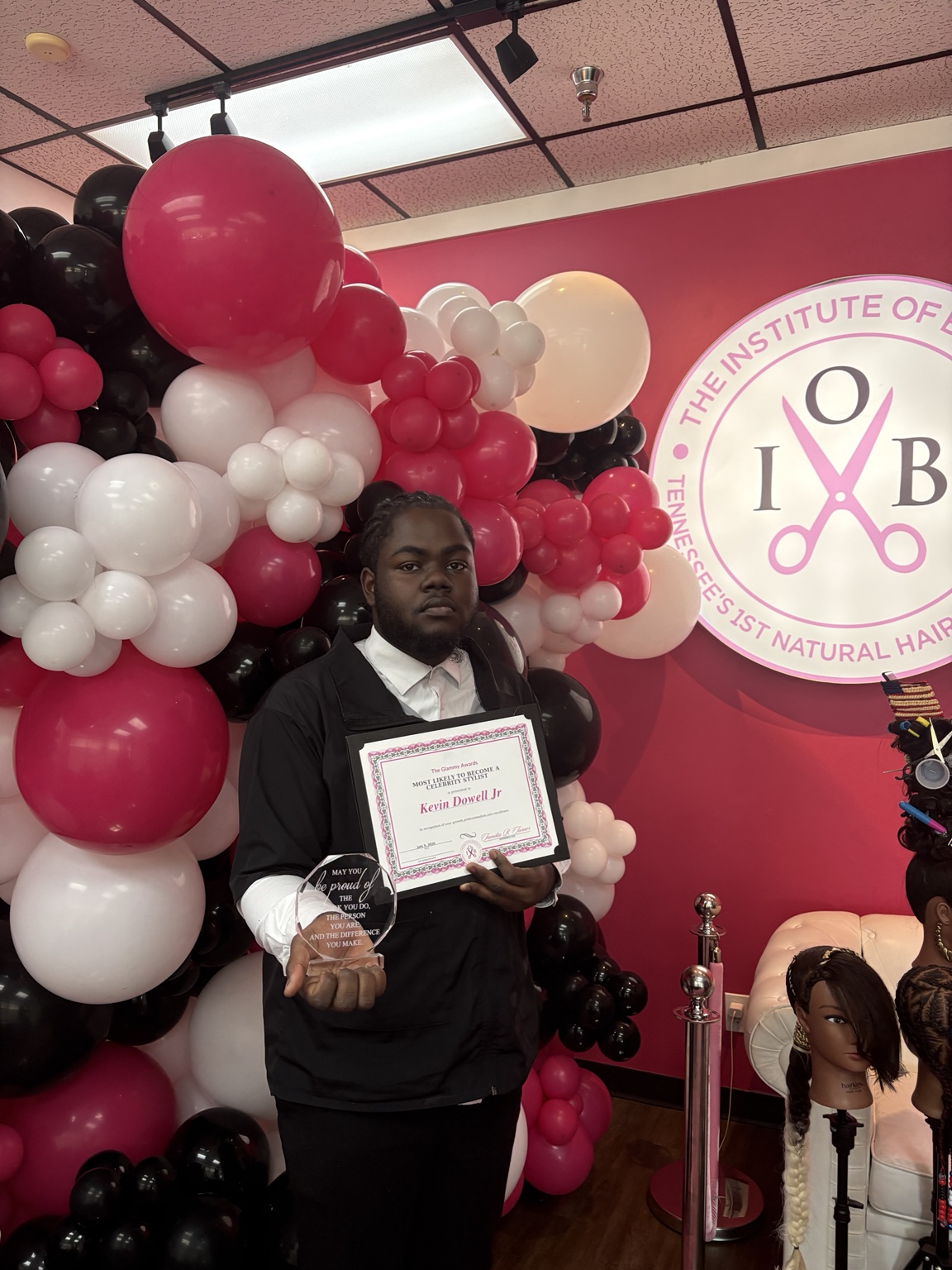 Kevin Dowell Jr. holding his student award at The Institute of Beauty